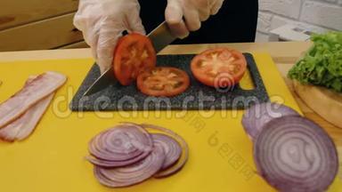 切菜。妇女的手戴玻璃纸手<strong>套用</strong>刀切新鲜的西红柿，旁边切洋葱